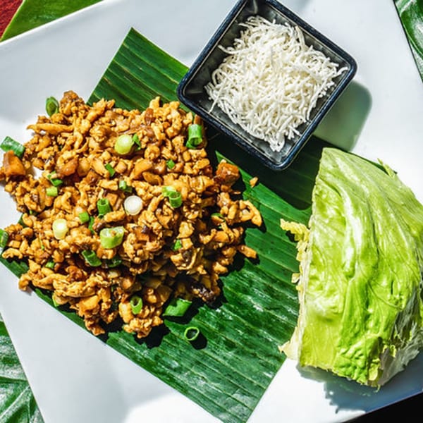 Thai lettuce wraps with minced chicken, green onions, and a side of crispy noodles.