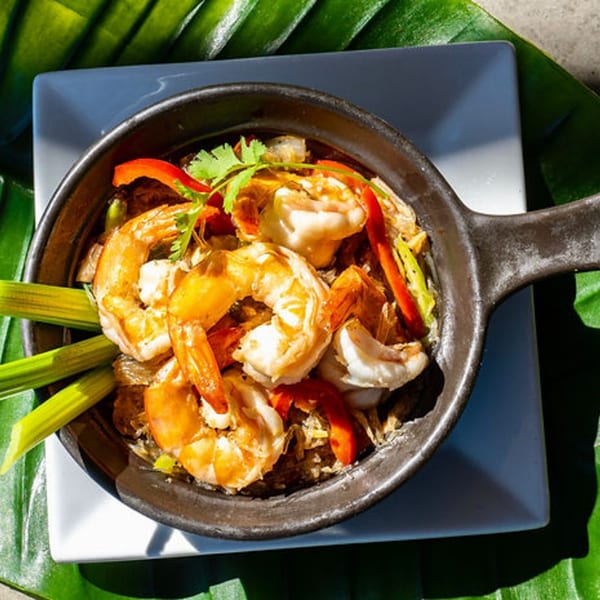 Thailicious' Thai shrimp dish with red peppers, cilantro, and green onions in a skillet.