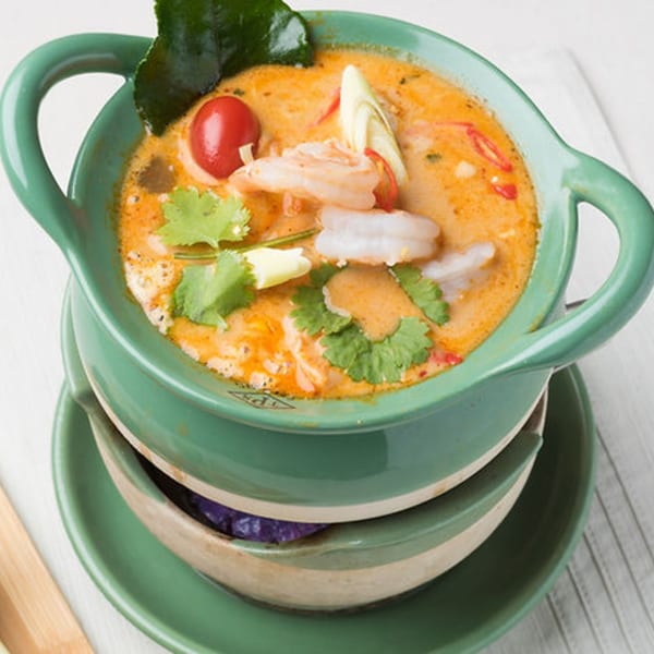 Thailicious Tom Yum Goong soup with shrimp, cherry tomato, and herbs in a green bowl.