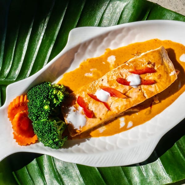 Thailicious' Panang Salmon, a salmon fillet in red curry sauce with broccoli and carrots.