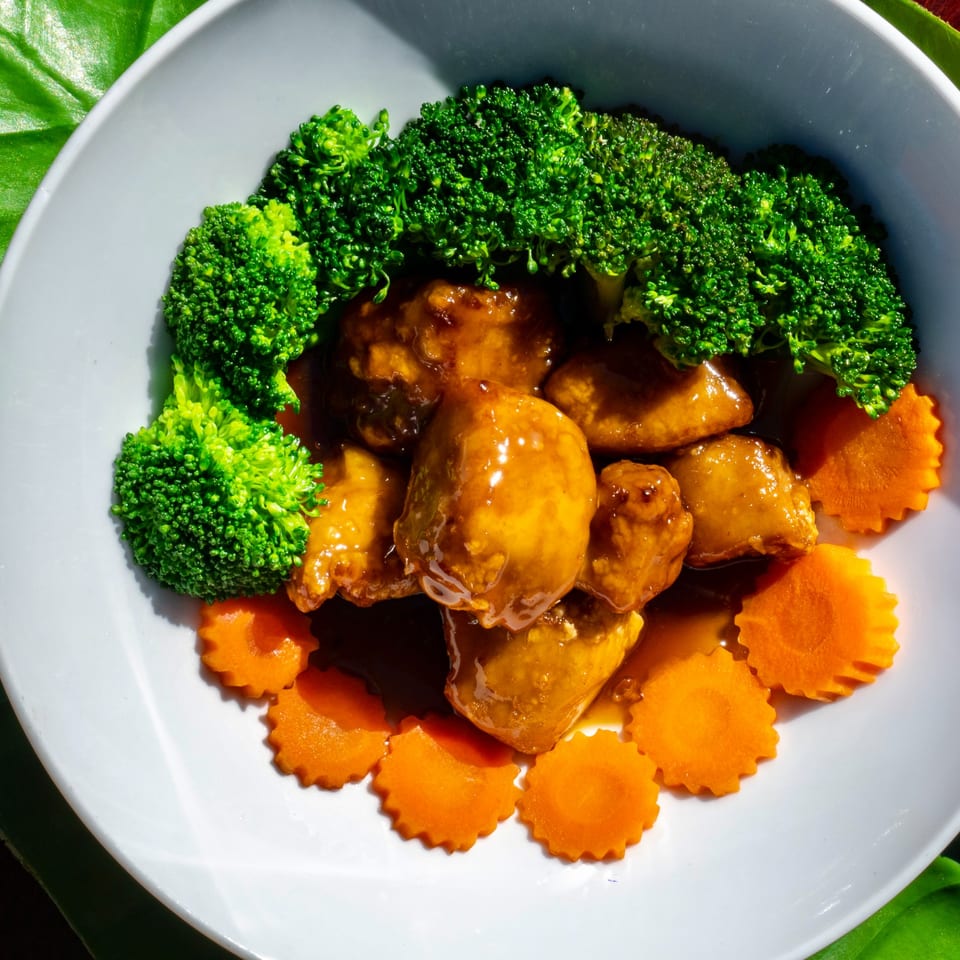 Thailicious's chicken with broccoli and carved carrots in a sweet brown sauce.